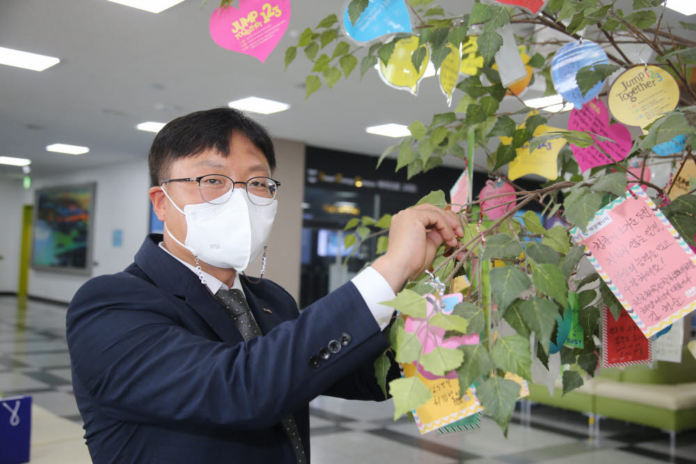 김용수 비온시이노베이터 대표가 감사나무에 카드를 걸고 있다.