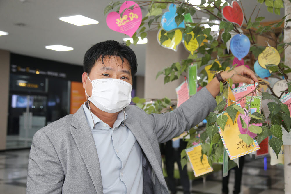 김환욱 삼환 대표가 30일 동신대 발전기금 기부 협약식에서 감사나무에 카드를 걸고 있다.